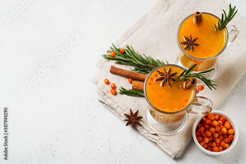 Sea buckthorn drink with rosemary in glass on white background