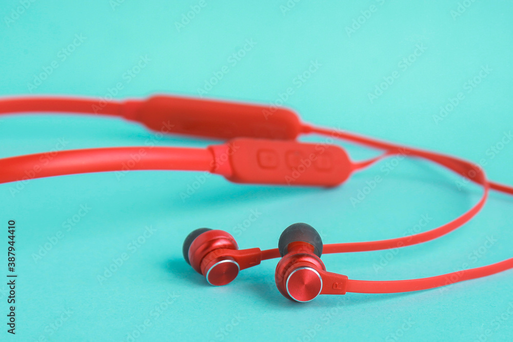 Naklejka premium Red earphones on bright blue background