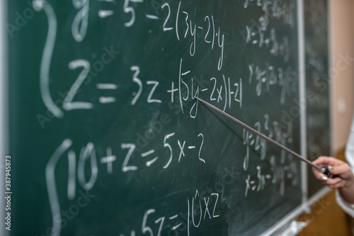 female hand showing math formula in chalkboard. Back to school
