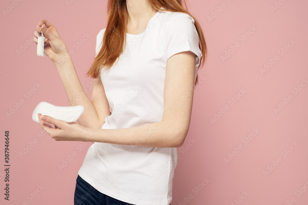 Woman with a pad in her hand on a pink background jeans T-shirt tampons hygiene frequency Woman with a pad in her hand on a pink background jeans T-shirt tampons hygiene frequency