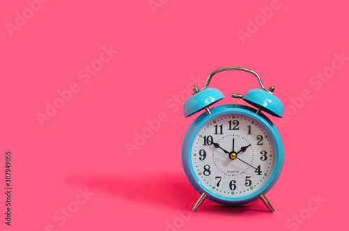 Classiac retro blue clock on pink background