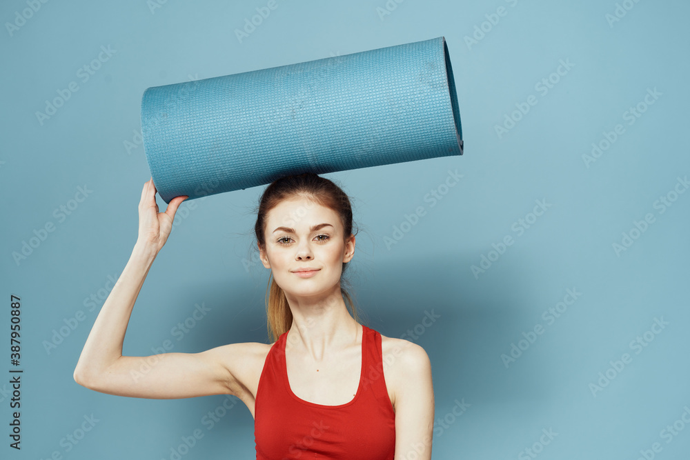 athletic woman with fitness mat exercise slim figure red t-shirt blue background athletic woman with fitness mat exercise slim figure red t-shirt blue background
