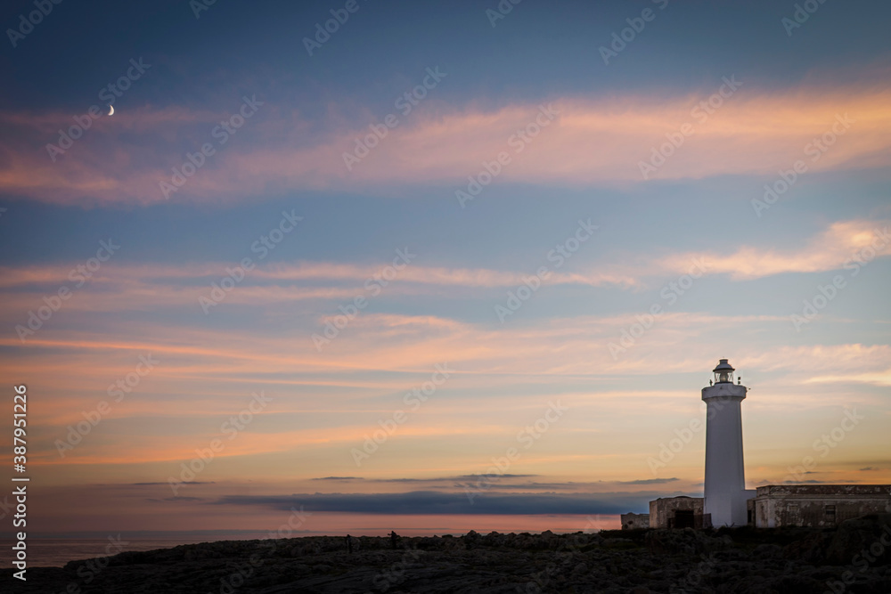 The lighthouse and the moon at sunset