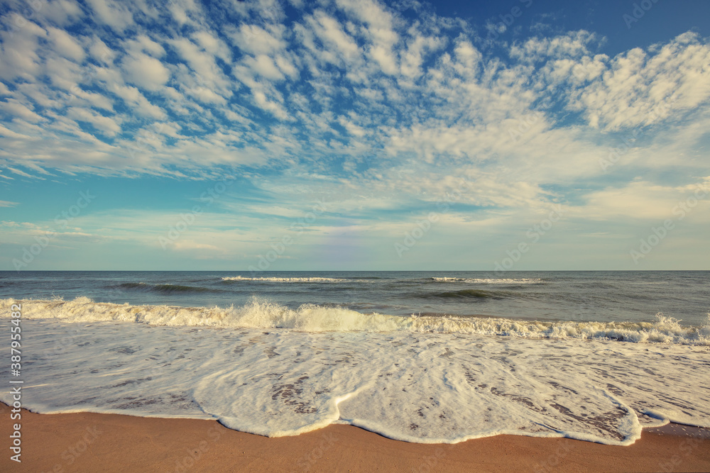 Seascape. Seashore on a sunny day. Landscape with ocean and bright evening cloudy sky