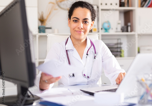 Portrait of friendly woman doctor explaining prescription to patient in office in hospital