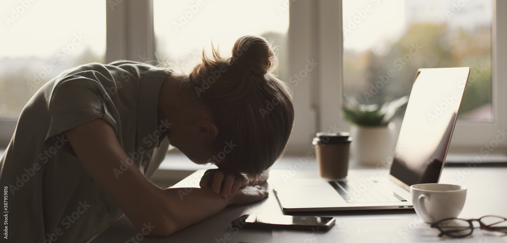 Tired and overworked business woman. Young exhausted girl sleeping on table during her work using laptop, digital tablet and smartphone. Entrepreneur, freelance worker or student in stress concept. Tired and overworked business woman. Young exhausted girl sleeping on table during her work using laptop, digital tablet and smartphone. Entrepreneur, freelance worker or student in stress concept.