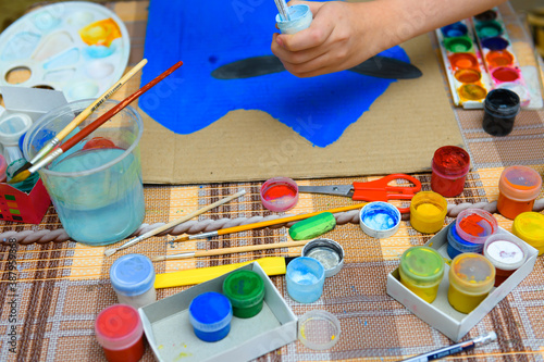 a girl drawing blue gouache cardboard, artistic creation at home, makes creative artwork