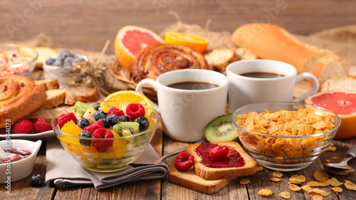 breakfast with coffee cup, fresh fruit, cereal and bread