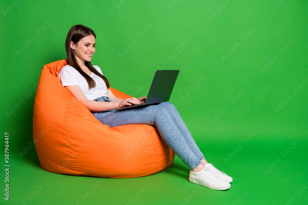 Profile photo of pretty young woman hold computer texting email freelancer dress white t-shirt jeans sneakers isolated on green background Profile photo of pretty young woman hold computer texting email freelancer dress white t-shirt jeans sneakers isolated on green background