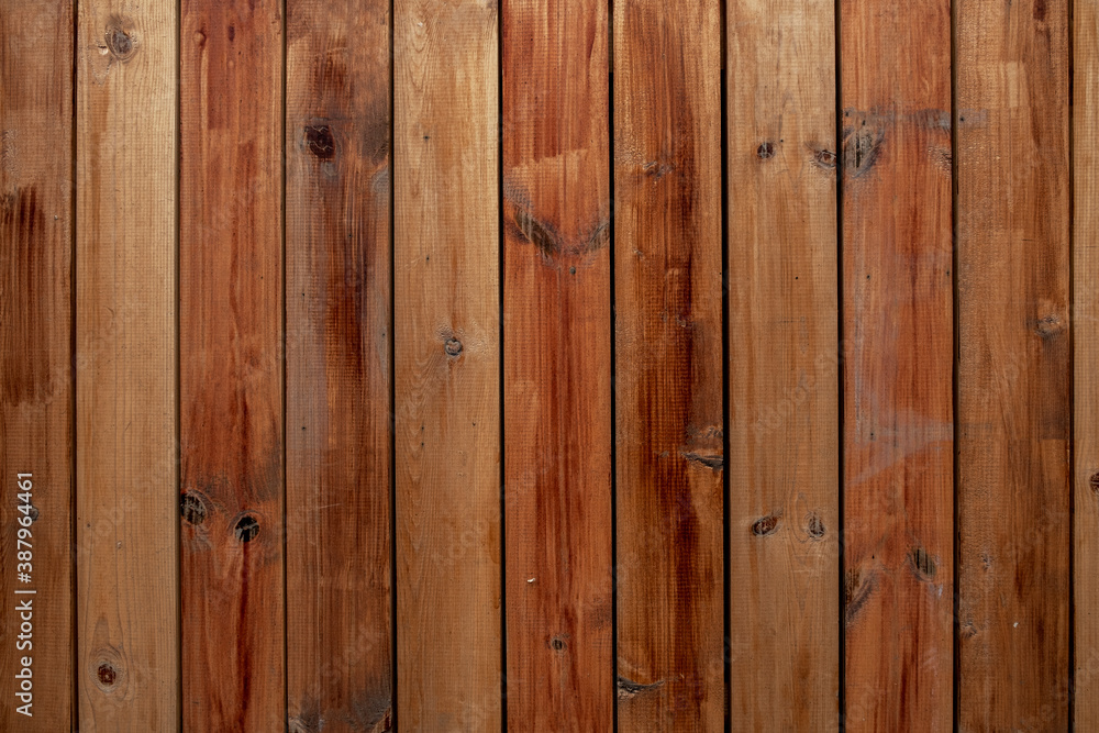 Naklejka premium old wooden fence made from gray brown red planks. vertical lines. rough surface texture