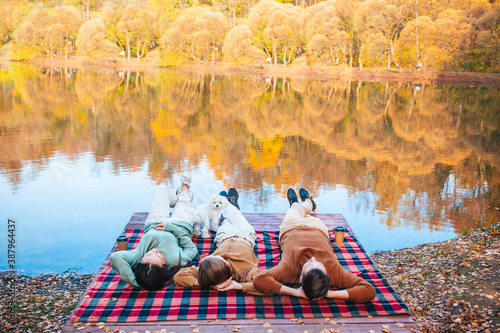 Beautiful family at autumn warm day near lake photo