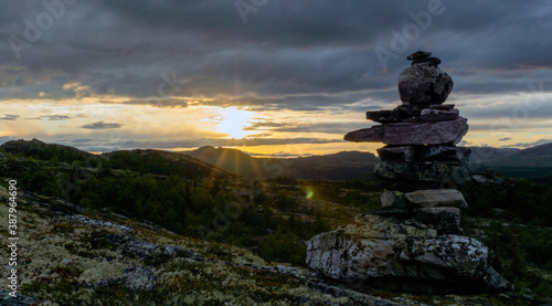 Cairn outdoors in nature during golden hour and sunset. Panoramic view. Travelling and landscapes concept. © Jon Anders Wiken
