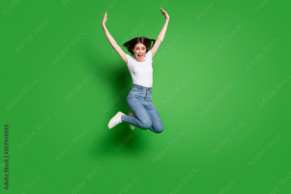 Full body photo of energetic girl jump raise arms wear casual style clothes isolated over green color background Full body photo of energetic girl jump raise arms wear casual style clothes isolated over green color background