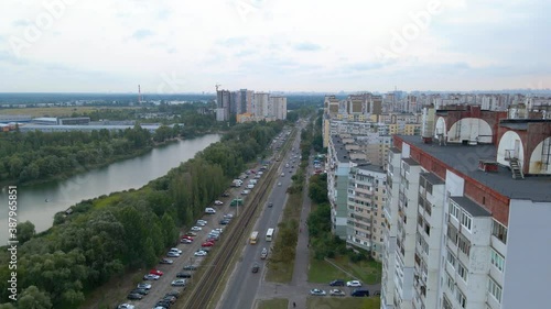 Aerial view of traffic on the Mykoly Zakrevskoho street, a river and old apartment buildings, in Troieshchyna neighborhood, cloudy day, in Kiev city, Ukraine - rising, drone shot photo