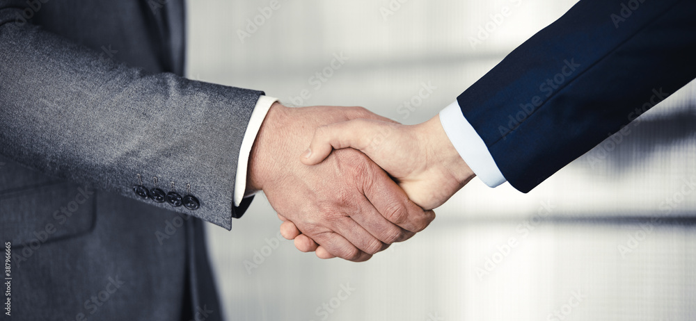 Business people in office suits standing and shaking hands, close-up. Business communication concept. Handshake and marketing Business people in office suits standing and shaking hands, close-up. Business communication concept. Handshake and marketing