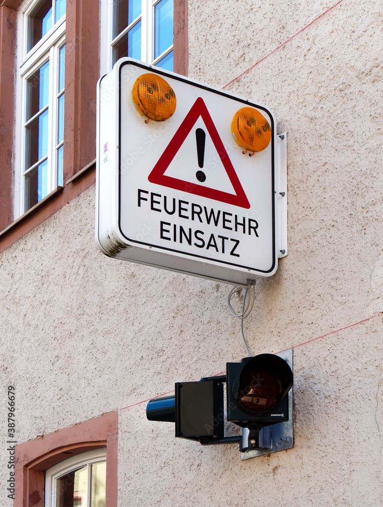 Sign on a facade indicating that the yellow warning lights flash when