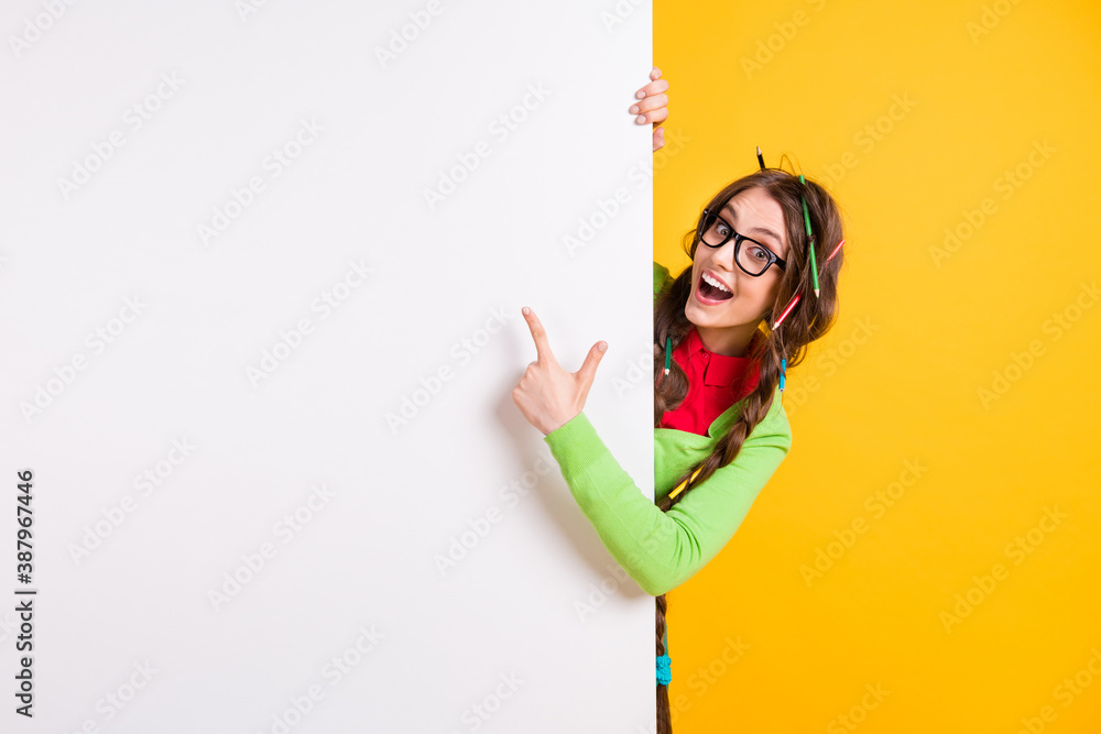 Portrait of pretty funky clever cheerful girl demonstrating copy space novelty isolated over bright yellow color background Portrait of pretty funky clever cheerful girl demonstrating copy space novelty isolated over bright yellow color background