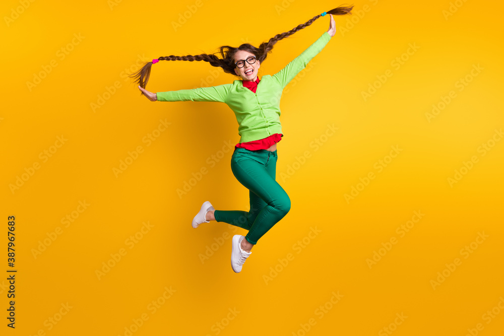Full length body size view of nice funky crazy carefree childish cheerful girl jumping having fun isolated bright yellow color background Full length body size view of nice funky crazy carefree childish cheerful girl jumping having fun isolated bright yellow color background