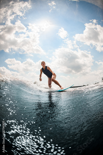 Photography wet woman black swimming vest rides down the river wave on wake board