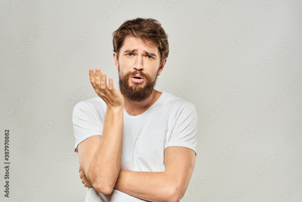 man in white t-shirt gesturing with his hands studio dissatisfaction lifestyle light background man in white t-shirt gesturing with his hands studio dissatisfaction lifestyle light background
