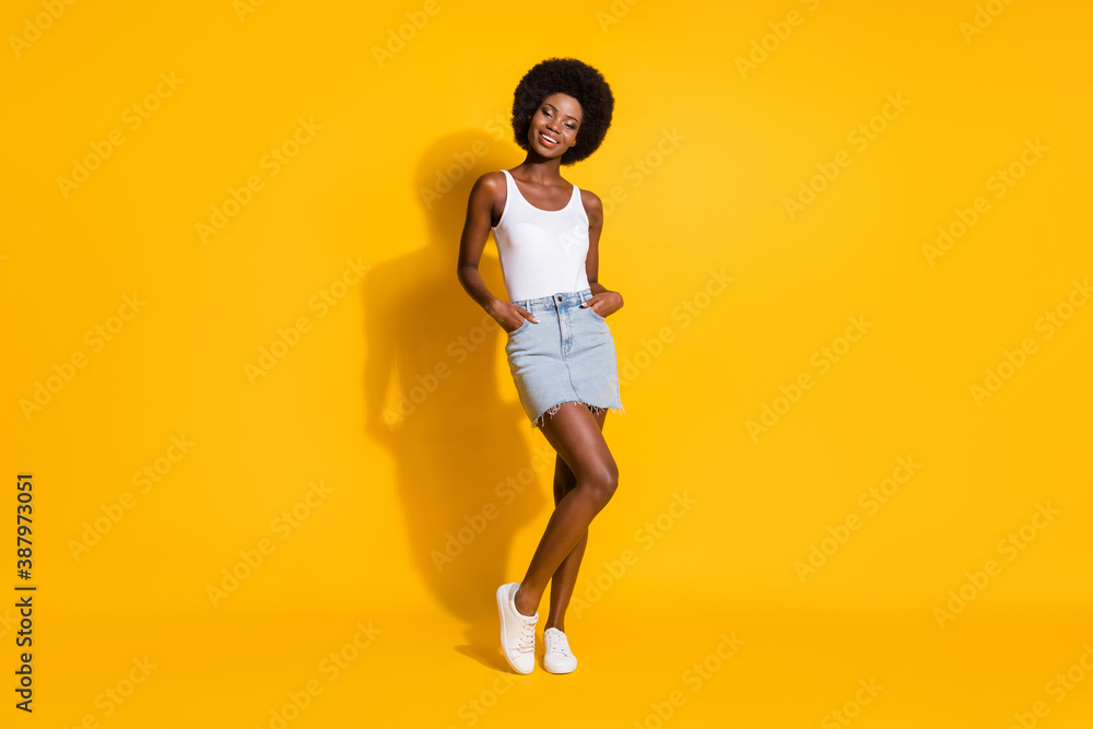 Photo of charming black young girl palms pockets look camera shiny smile wear white singlet isolated yellow color background