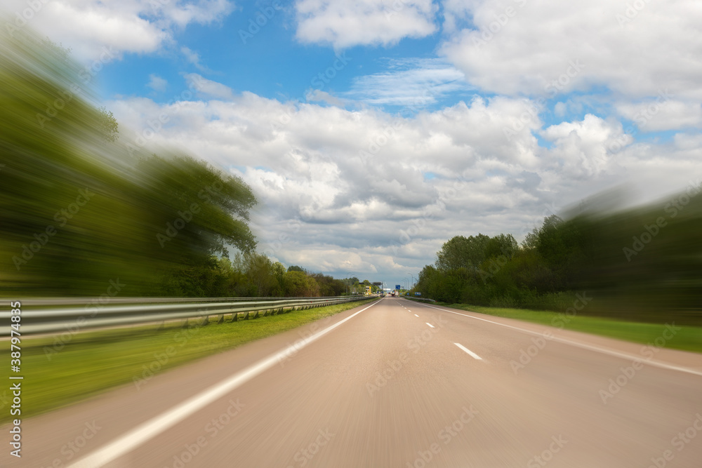 Emtpy suburaban highway car road with motion blurred fast speed driving against blue sky on background. Perspective vehicle motorway landscape Emtpy suburaban highway car road with motion blurred fast speed driving against blue sky on background. Perspective vehicle motorway landscape