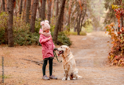 Little girl with dog running into forest