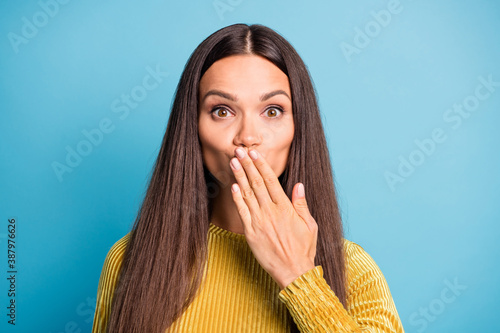 Photo portrait of woman covering mouth with hand isolated on pastel blue colored background photo