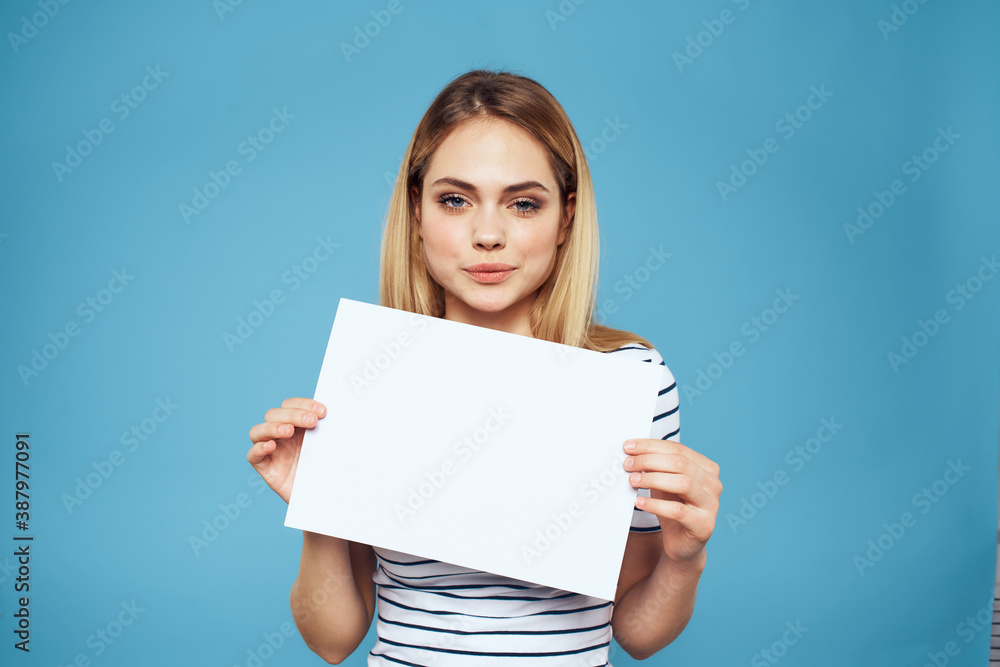Emotional woman holding a sheet of paper in her hands lifestyle close-up blue background Copy Space Emotional woman holding a sheet of paper in her hands lifestyle close-up blue background Copy Space