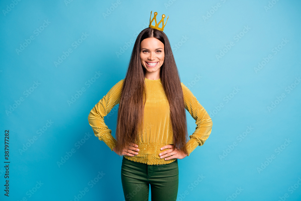 Photo portrait of smiling woman wearing golden crown isolated on pastel blue colored background Photo portrait of smiling woman wearing golden crown isolated on pastel blue colored background