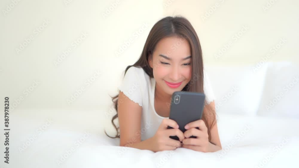 Beautiful Adult Girl Interacting with Smartphone while Laying on Bed Beautiful Adult Girl Interacting with Smartphone while Laying on Bed