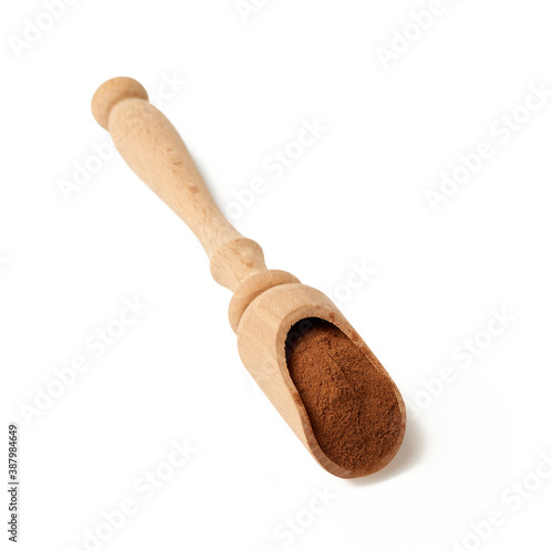 ground cinnamon in a wooden spoon, spice isolated on white background