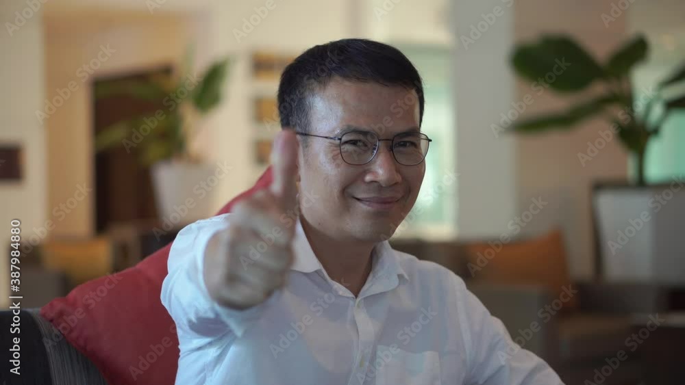 Young casual man smiling to the camera with giving thumbs up Young casual man smiling to the camera with giving thumbs up