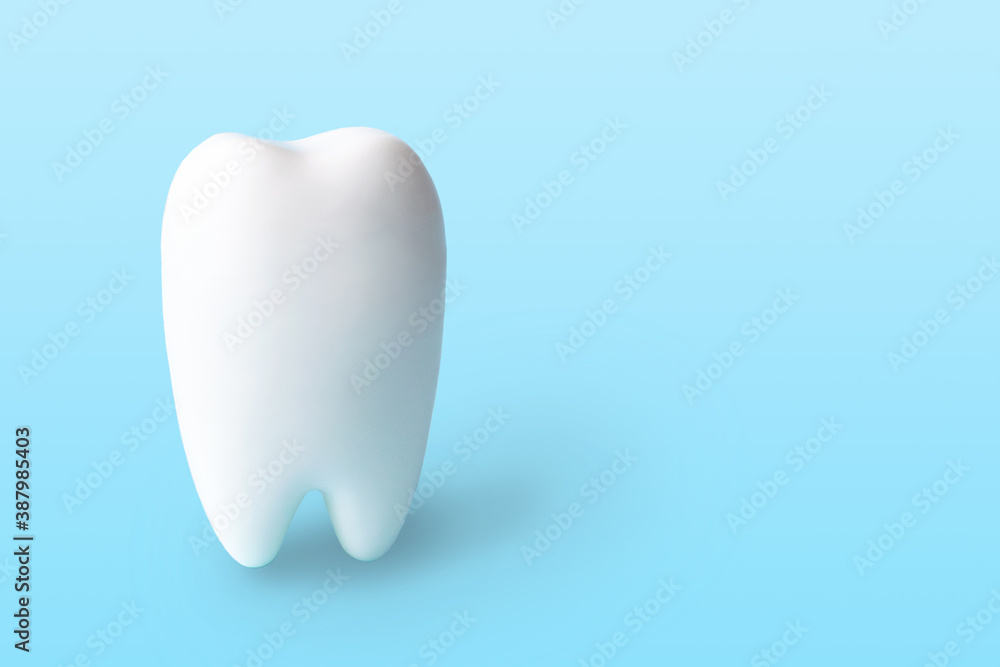 White tooth isolated on light blue background with copy space. Oral hygiene concept for dentistry clinic. Medical object, dental health, copy space. White tooth isolated on light blue background with copy space. Oral hygiene concept for dentistry clinic. Medical object, dental health, copy space.
