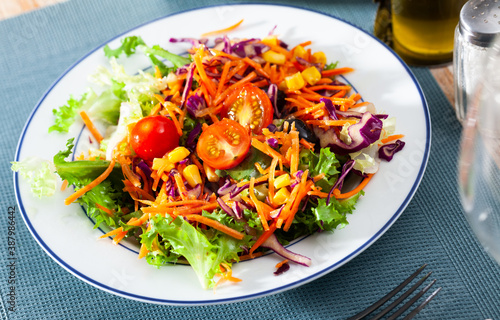 Fresh mixed salad with lettuce  corn  olives and cherry tomatoes at plate