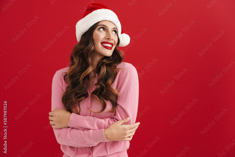Beautiful happy girl in Santa Claus hat smiling and looking aside Beautiful happy girl in Santa Claus hat smiling and looking aside