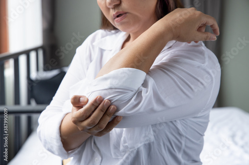 middle aged southeast asian woman suffers from elbow joint pain or osteoporosis