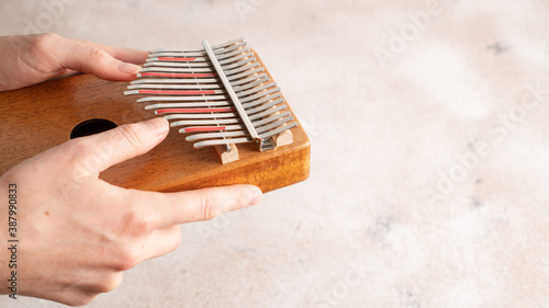 Hands playing the African instrument Kalimba. Mbira is musical instrument. Side view