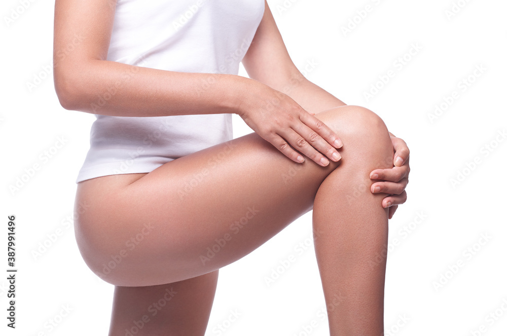 Woman in underwear presses her hands to her sore knee