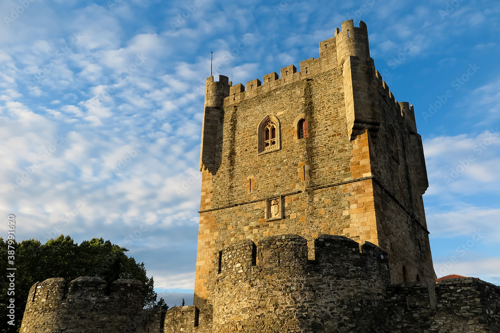 Tower of the Castle of Bragança, under sunset light, blue sky and clouds in the background, city of Bragança, capital of the district of Bragança, sub-region of Terras de Trás-os-Montes, Portugal
