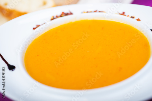 Lentil soup in a white plate on the table in a restaurant