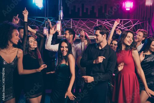 Photo portrait of cheerful excited people dancing together at luxury party in pink and blue neon lights