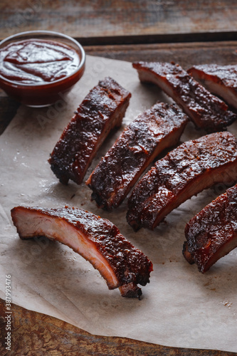 Glazed  pork ribs BBQ with ketchup on wooden background.