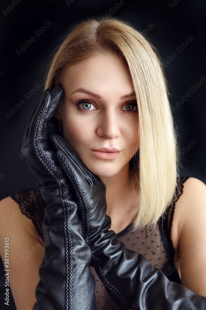 Beautiful sexy blonde in leather gloves on a black background Beautiful sexy blonde in leather gloves on a black background