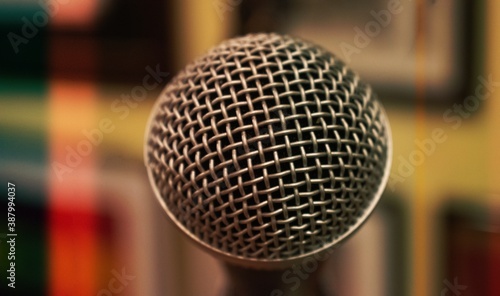 Close up on a metal microphone, with a blurry background