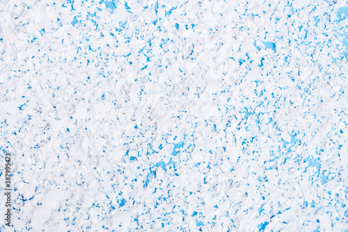 Top view of artificial snow on blue background, new year concept