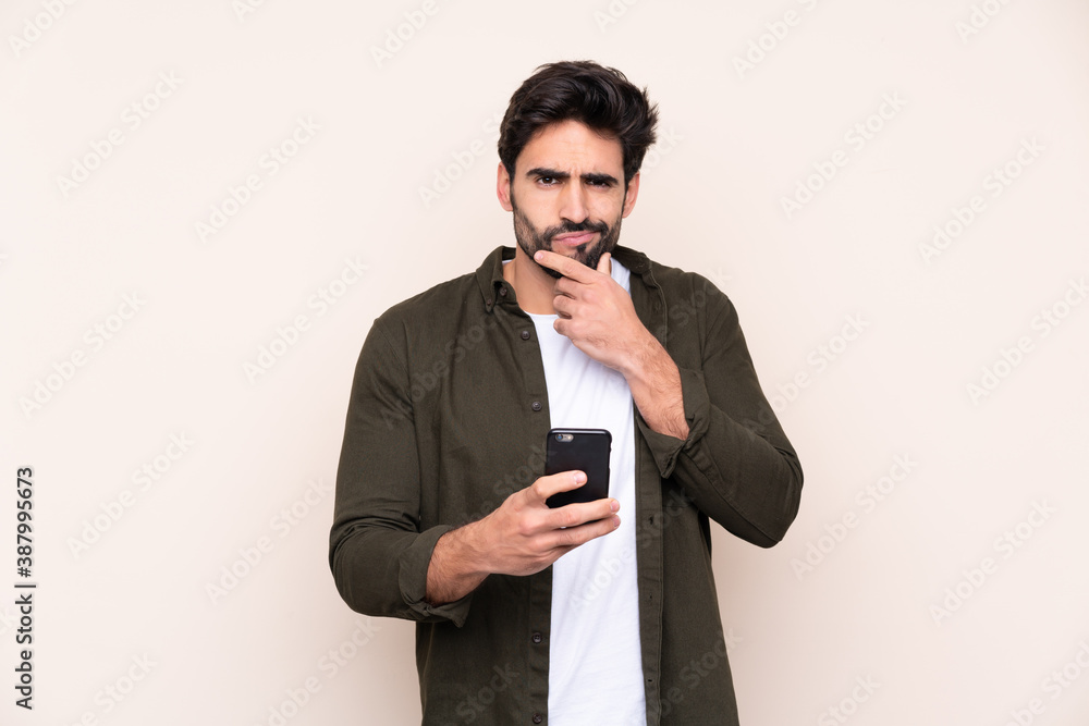 Young handsome man with beard over isolated background thinking and sending a message Young handsome man with beard over isolated background thinking and sending a message