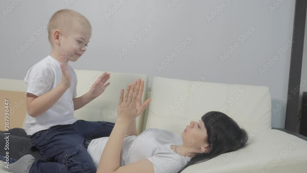 happy family concept. mom and son boy clap their hands. mother a and her son sit lifestyle clapping hands. happy family little kid blonde playing with mom happy family concept. mom and son boy clap their hands. mother a and her son sit lifestyle clapping hands. happy family little kid blonde playing with mom