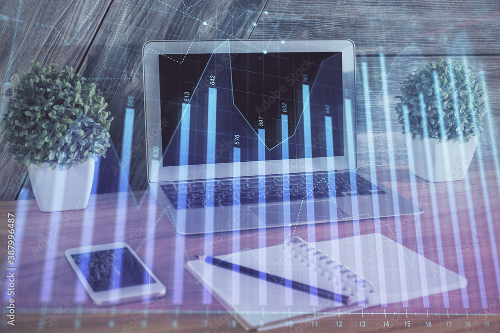 Financial chart drawing and table with computer on background. Double exposure. Concept of international markets. Financial chart drawing and table with computer on background. Double exposure. Concept of international markets.