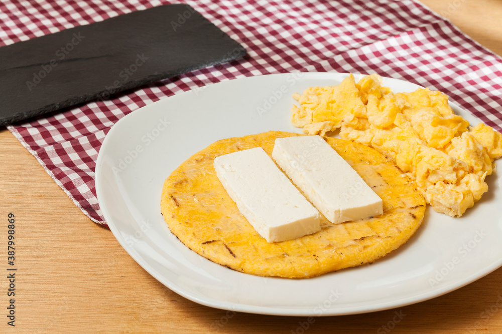 Tasty traditional breakfast in Colombia; Arepa of yellow corn with cheese and scrambled eggs. Tasty traditional breakfast in Colombia; Arepa of yellow corn with cheese and scrambled eggs.